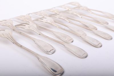 six silver spoons are arranged in a row on a white surface