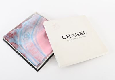 une boîte blanche contenant un foulard rose et bleu