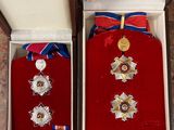 two medals are in a box with a ribbon around them