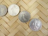 three silver coins sitting on top of a wooden floor next to each other