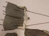 a silver purse with a chain around it and a purse with a chain around it