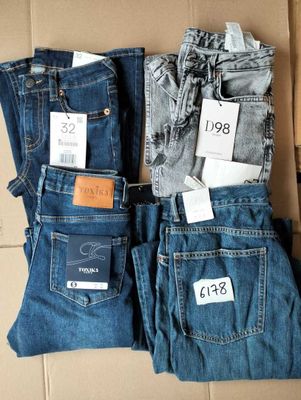 trois paires de jeans pour homme posées sur un carton