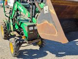 a green tractor with a large bucket attached to it