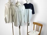 three mannequins and a chair in front of a white wall
