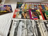 a lot of magazines on a bed with a white sheet