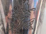 a silver cup with a bird on it on a table