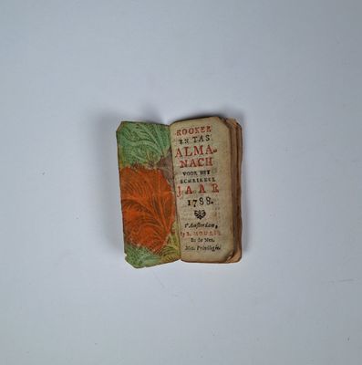 an old book with a red flower on top of it
