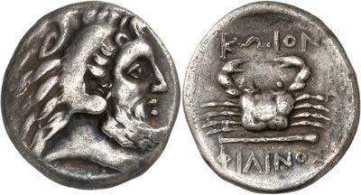 a close up of a silver coin with a skull on it