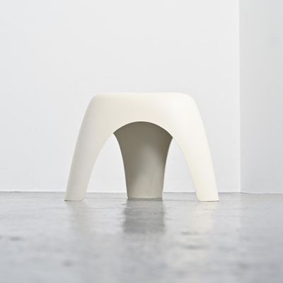 a white stool sitting in the middle of a room