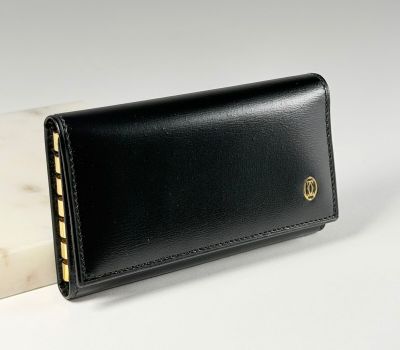 un portefeuille en cuir noir avec un bloc de marbre blanc en arrière-plan