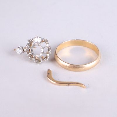 une bague en or et une bague en diamant posées sur une surface blanche