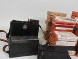 an old camera and a stack of books sitting on a table