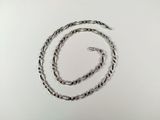 a close up of a silver chain on a white surface