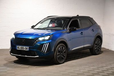 Le SUV bleu est garé dans une pièce blanche au sol à carreaux.