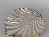petit plat en forme de coquillage plaqué argent sur un fond blanc