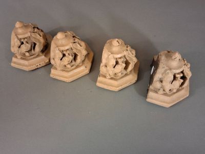 trois petites statues représentant un homme et une femme assis l'un sur l'autre