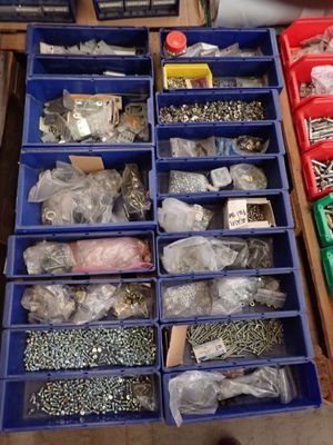 many different types of nuts and screws in the bins