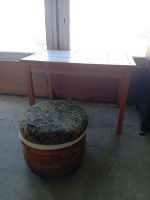 a small table with a stool in front of a window