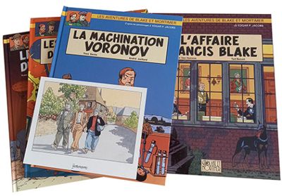 Trois livres pour enfants sont empilés les uns sur les autres devant un immeuble