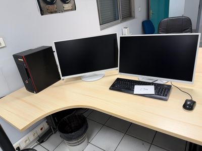 a desk with two monitors and a keyboard on it