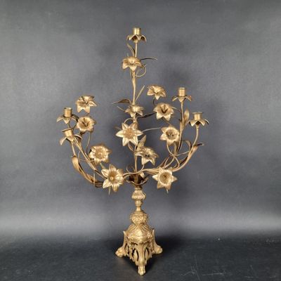 an antique brass candelab with flowers and leaves on a stand