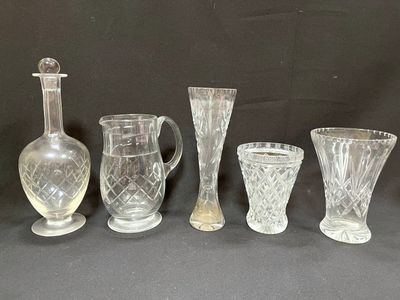 five glass vases and a decanter sitting on a table