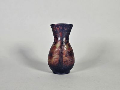 un petit vase posé sur une surface blanche