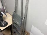 a metal ladder leaning against a wall next to a table