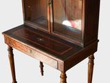 a wooden cabinet with a glass door on top of it