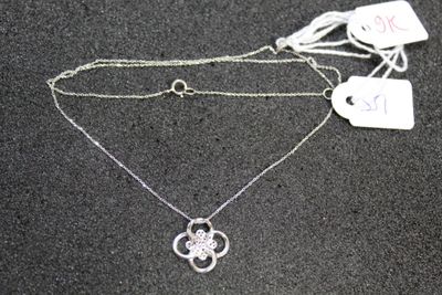 two silver necklaces on a black surface with a price tag
