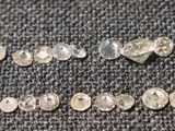 un gros plan sur un groupe de diamants blancs posés sur un tissu noir