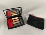 a close up of a compact case with makeup on a white surface