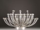 a silver vase with many balls in it on a table