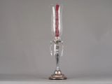 a silver vase with a red candle inside of it