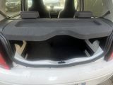 the back of a white car with its trunk open in a parking lot