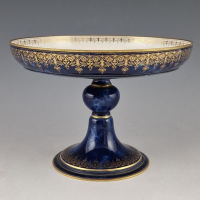 an antique blue and gold footed cake plate on a pedestal