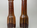 two vases sitting side by side on a white surface