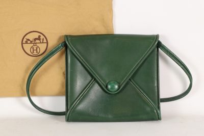 sac à main en cuir vert, orné d'un bouton vert sur le devant et d'un compartiment marron à l'arrière