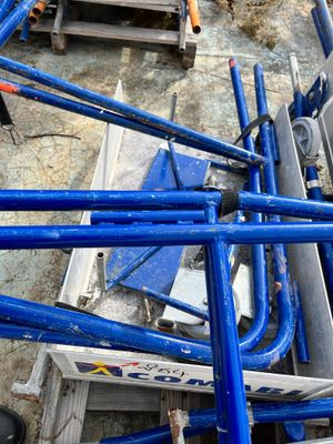 a pile of blue pipes on the ground next to a building