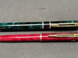 two pens sitting next to each other on a table