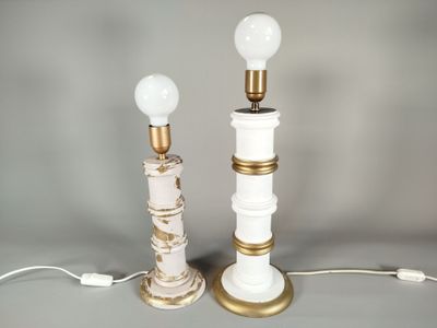 une paire de lampes de table blanches et dorées posées sur une surface grise