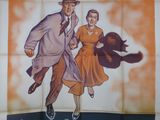 une vieille affiche de cinéma représentant un homme et une femme en train de courir