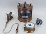 a small copper object with a rope and a clock