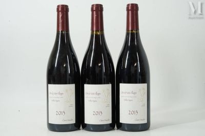 trois bouteilles de vin rouge sont alignées sur une surface blanche