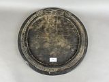 une assiette noire et dorée posée sur une table blanche