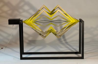 a yellow and black sculpture on a stand with a white background