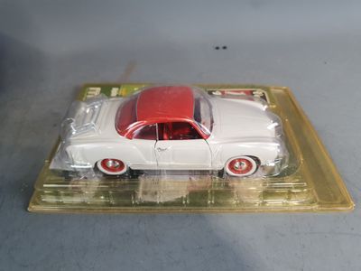 a white toy car with a red top on a plastic tray