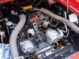 a red car with a large engine in it ' s trunk
