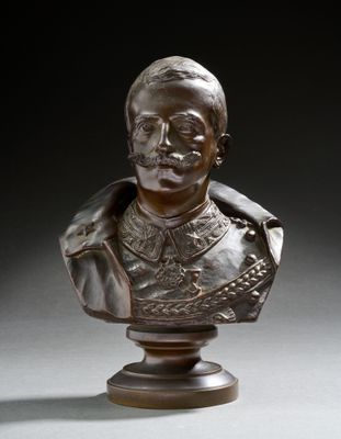 un buste en bronze représentant un homme moustachu, posé sur un socle