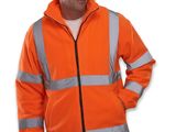 un homme vêtu d'une veste orange, debout, les mains dans les poches